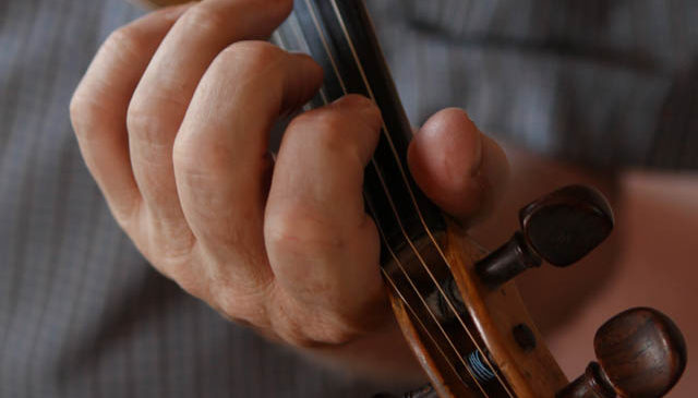 James Kelly's hand on the fingerboard of his fiddle