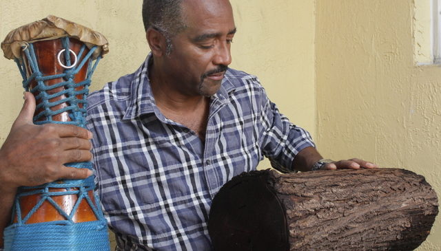 Ezequiel with okónkolo (the smallest batá drum) and a log of similar size