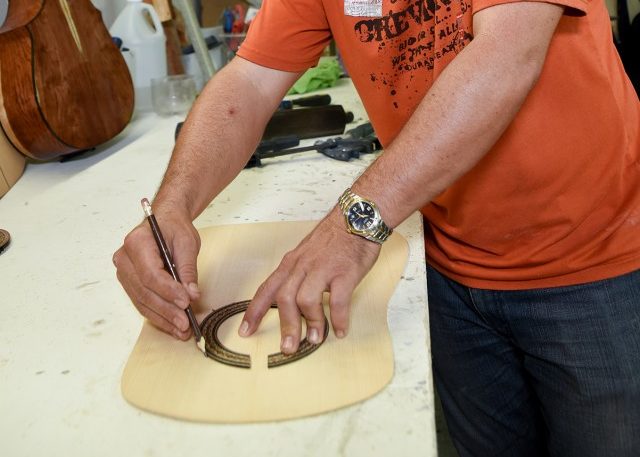 A pencil is used to trace where the sound hole will be cut